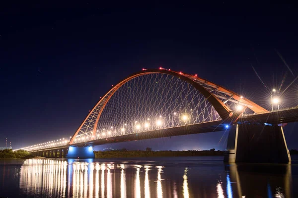 Nehir Ob gece boyunca köprü. Köprü ışıkları gece gökyüzünde parlayan.