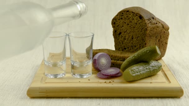 伏特加倒进杯子里 桌子上是俄罗斯的传统小吃 — 图库视频影像
