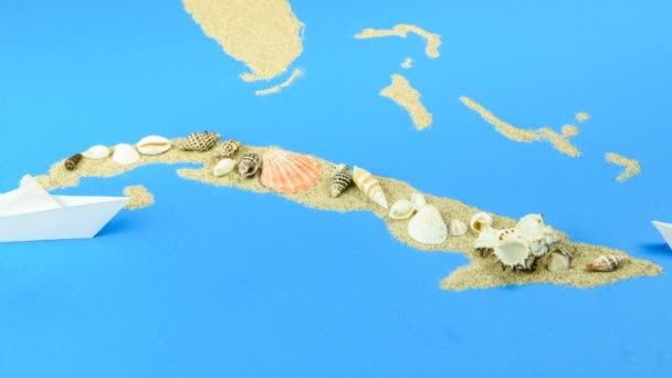 一艘纸船驶离古巴海岸 古巴的轮廓是由沙子排列在上面的贝壳 — 图库视频影像