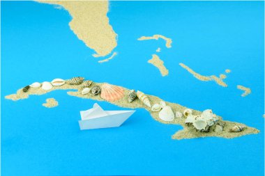 Bir kağıt tekne Küba kıyılarında yelken. Küba kıvrımlarına kum, üst - kabukları ile sıralanır.