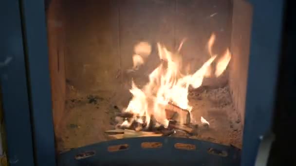 Un homme allume un feu dans la cheminée. Bois de chauffage sec, flamme dans le poêle .