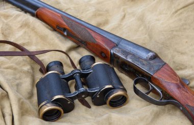 Vintage av tüfeği ve dürbün bir haki çadır üzerinde yalan.