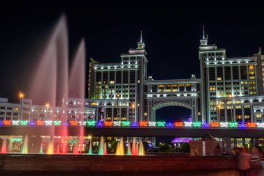 Nur-Sultan, Kazakistan, Ağustos 2019, Kazakistan'ın başkentinin merkezinde ki yüksek binaların arka planında aydınlatmalı çeşmeler.