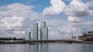 Kazakistan, Nur Sultan, Ağustos 2019. Gökdelenler ve bir yaya köprüsü, bulutlar gökyüzünde çalıştırmak, zaman atlamalı.