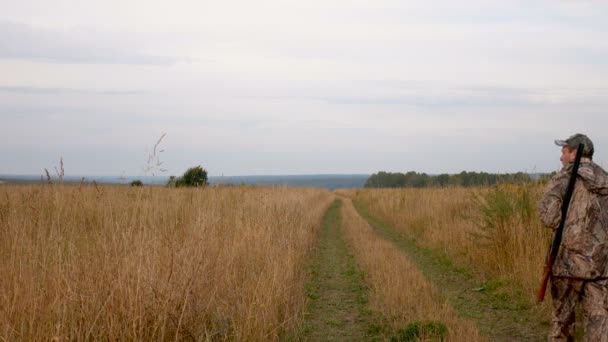 Cacciatore Con Una Pistola Sulla Strada Attraverso Campo Autunno Stagione — Video Stock