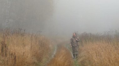 Avcı yolda. Sabah ın erken saatlerinde, sis. Sonbahar, yol boyunca sarı çimen.