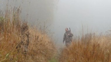 Avcı yolda. Sabah ın erken saatlerinde, sis. Sonbahar, yol boyunca sarı çimen.