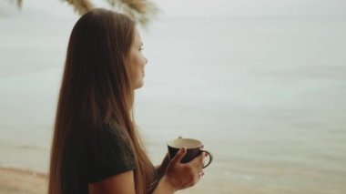 Sabahları balkonda tek başına kahve ya da çay içen, mavi deniz manzaralı, pencereden bakan, Mısır, 4k