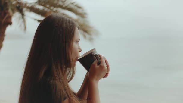 Samotna kobieta pije rano kawę lub herbatę na balkonie z niebieskim widokiem na morze, punkt widzenia z okna, Egipt, 4k — Wideo stockowe