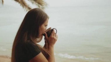 Sabahları balkonda tek başına kahve ya da çay içen, mavi deniz manzaralı, pencereden bakan, Mısır, 4k