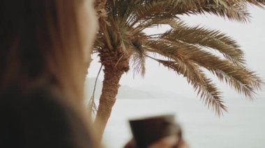 Sabahları balkonda tek başına kahve ya da çay içen, mavi deniz manzaralı, pencereden bakan, Mısır, 4k