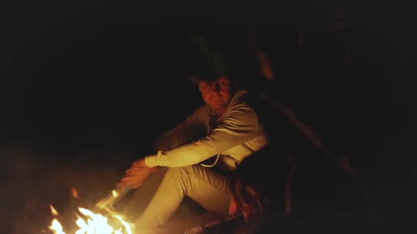 Grupo de amigos se divertindo perto da fogueira na praia perto do mar à noite, 4k — Vídeo de Stock