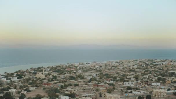 Pôr do sol surpreendente em montanhas de Egipto Sinai e mar azul no horizonte, vista bonita à vila pequena do alto das montanhas, picos das montanhas, 4k — Vídeo de Stock