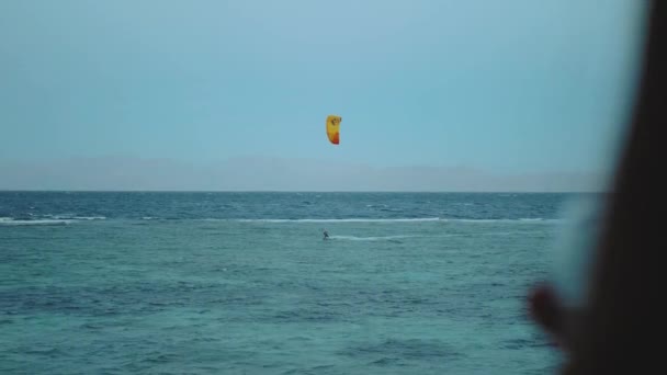 女性はワインを飲み、人々はダハブエジプトの美しい澄んだ水でサーフィンカイトを見てください。山を背に青い海を探索し、人々はカイトサーフィン、 4k — ストック動画