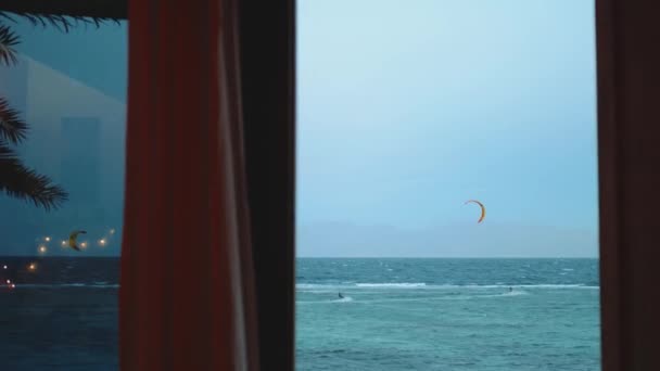 Люди кайт-серфінг у прекрасній чистій воді в Дахабському Єгипті точки зору з вікна. Дослідження синього моря з горами на задньому плані і люди, що катаються з повітрям, 4k — стокове відео