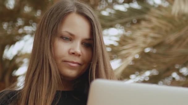 Primer plano de la hermosa mujer estudiante o freelancer que trabaja en un ordenador portátil, mujer sentada en el balcón con vista superior de la palma y el mar, full hd — Vídeos de Stock