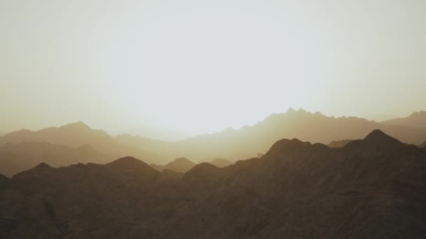 Удивительный закат в горах пустыни Египет. Огни, исходящие от солнца, освещают небо над горами. — стоковое видео