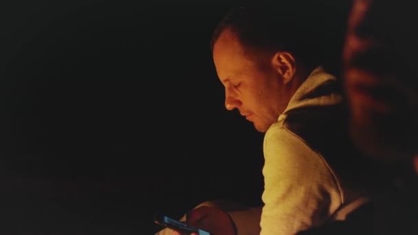 Grupo de amigos divirtiéndose cerca de la fogata en la playa cerca del mar por la noche, full hd — Vídeos de Stock