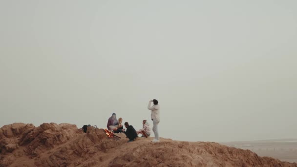 Groep mensen ontspannen op de top van een berg bij zonsondergang, zitten in de buurt van vreugdevuur, genieten van hun tijd - vriendschap, jeugd, full hd — Stockvideo