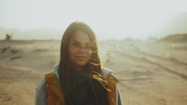 Portret van een mooie vrouw bij zonsondergang in woestijnbergen aan de horizon. Gelukkige jonge vrouw staande in de wind tegen Egypte woestijn zonsondergang landschap, full hd — Stockvideo