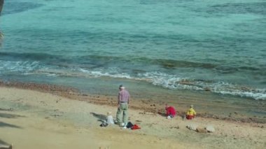 Büyükbabam ve torunlarım sahilde oynuyorlar, Mısır 'da, tam deniz kenarı.