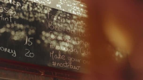 Rückansicht der Kundin Blick auf die Speisekarte an der Wand im vegetarischen Geschäft wählen Sie Getränke, frische Säfte in der Speisekarte in Dahab Shop, Ägypten, voll hd — Stockvideo
