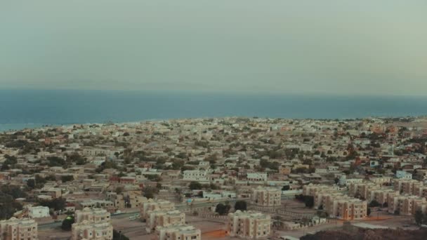 Increíble puesta de sol en Egipto montañas del Sinaí y el mar azul en el horizonte, hermosa vista al pequeño pueblo desde la cima de las montañas, picos de las montañas, hd completo — Vídeos de Stock