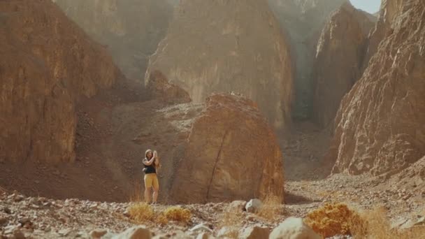 Mulher turística tirar fotos no desfiladeiro do deserto quente. Montanha rochas fundo, Egito, Sinai, hd completo — Vídeo de Stock