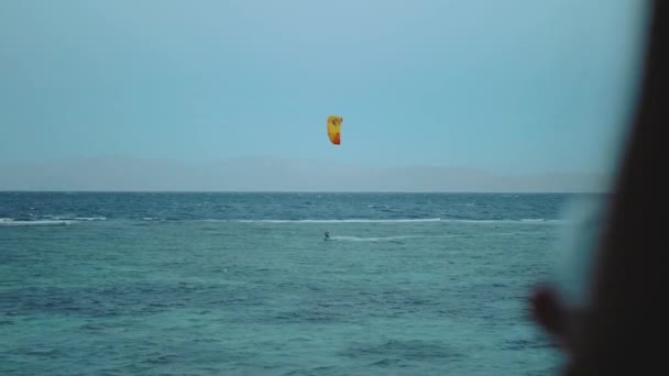 Primer plano de la mujer beber vino y mira cómo la gente Kite surf en la noche en el mar rojo de Egipto. Punto de vista desde la ventana, hd completa — Vídeos de Stock