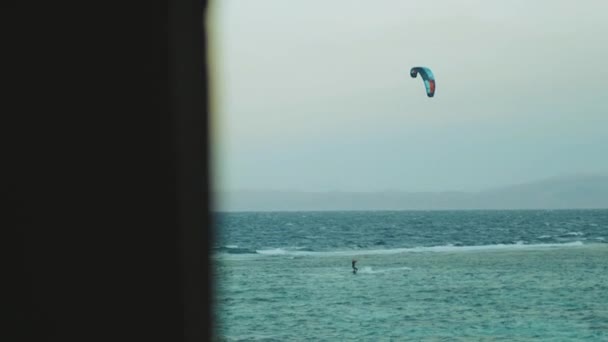 Alleen man vlieger surfen in de rode zee bij zonsondergang, Dahab Egypte, standpunt van het raam. Mensen windsurfen en kitesurfen, full hd — Stockvideo