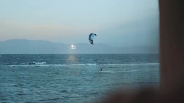 Man Kite surfar på kvällen vid Egyptens röda hav. Utsikt från baksidan av kvinnan, full hd — Stockvideo