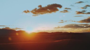 Sahra Çölü 'nde altın kum ve bulutlu gökyüzü. Gün batımı. Güzel çöl manzarası. Sahra Çölü. Kum tepeleri Arap çölü. Kum tepecikleri dalga deseni. Doğa arka planı, Fas, 4k