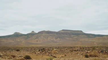 Güzel panoramik kaya manzarası, Fas 'ta renkli bir kanyonda taşlar ve kayalar, bulutlu gökyüzü, 4k