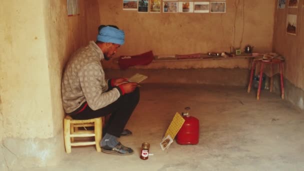 Homem marroquino faz cartões postais para turistas antiga fortaleza ksar Ait Ben Haddou, berbere, Marrocos perto de Ouarzazate nas montanhas do Atlas, 4k — Vídeo de Stock