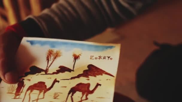 Nahaufnahme marokkanischen Mann fertigt Postkarten für Touristen alte Festung ksar Ait Ben Haddou, Berber, Marokko in der Nähe von Ouarzazate im Atlasgebirge, voll hd — Stockvideo