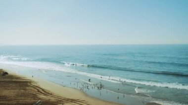 Erkek balıkçılar martı sürüsünü diğer balıklarla besler, kumlu kıyı şeridinde kırılan güzel deniz dalgalarını, derin mavi okyanus suyunu ve Fas 'ın köpüklü dalgalarını görür.