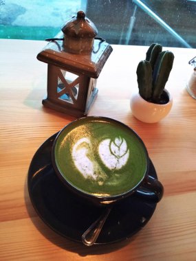 Japon yeşil matcha latte çay süt sanat siyah fincan fener kaktüs fotoğraf