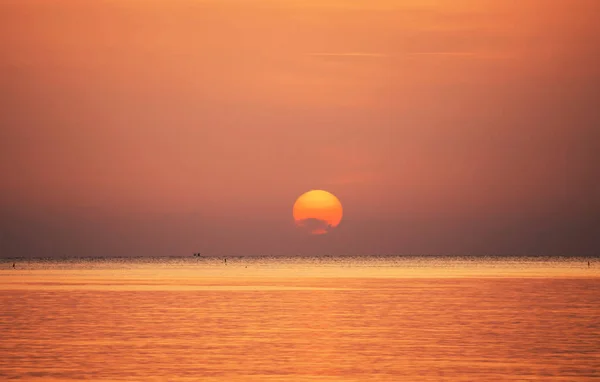 雲と空に囲まれた朝の海で日の出が美しい静かな雰囲気感じて孤独 — ストック写真
