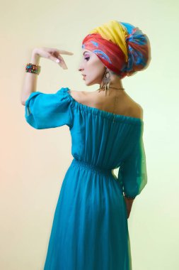 Türban güzel dans eden kadın. Moda fotoğraf. Güzellik kız renkli türban ve mavi elbise