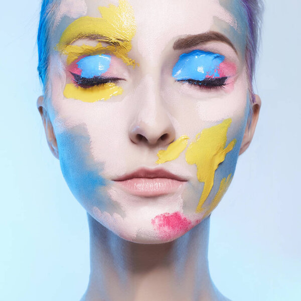 young woman with paint on her face. painted mask girl portrait