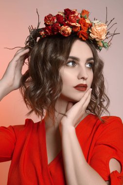 Güzel kız kıvırcık saçlı ve onları çiçeklenir. Yapmak yukarıya ve kırmızı olan kadın portresi muhteşem bahar elbise. Yaz sembolü