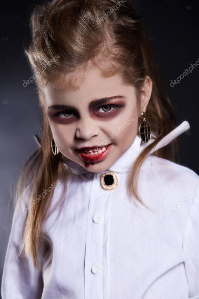 little vimpire child.little angry girl with halloween make-up.dracula kid with blood on her face.halloween holiday children