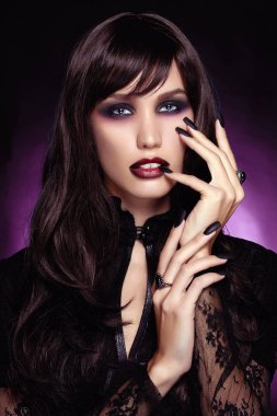 güzel genç vampir kadın. koyu mor arka plan üzerinde siyah saçlı seksi Halloween Kız