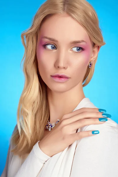 若いブロンドの女性の肖像画 美少女モデルのメイクアップ 青色の背景 — ストック写真