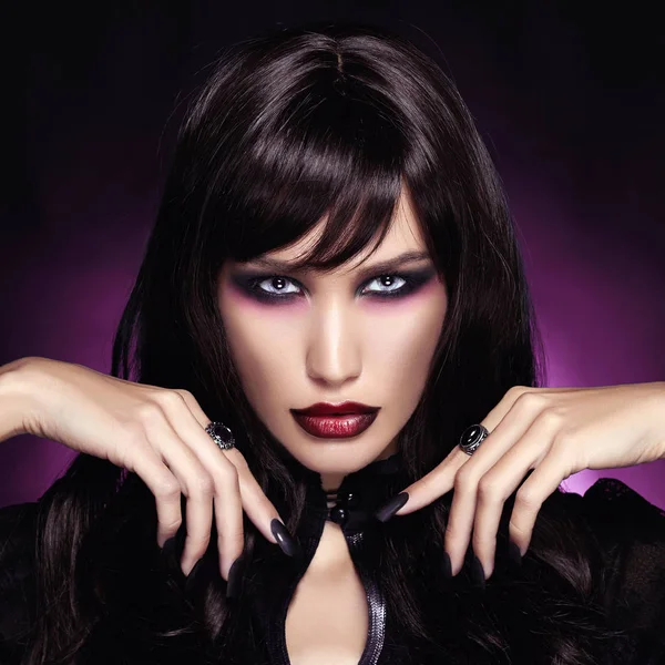 güzel genç vampir kadın. koyu mor arka plan üzerinde siyah saçlı seksi Halloween Kız