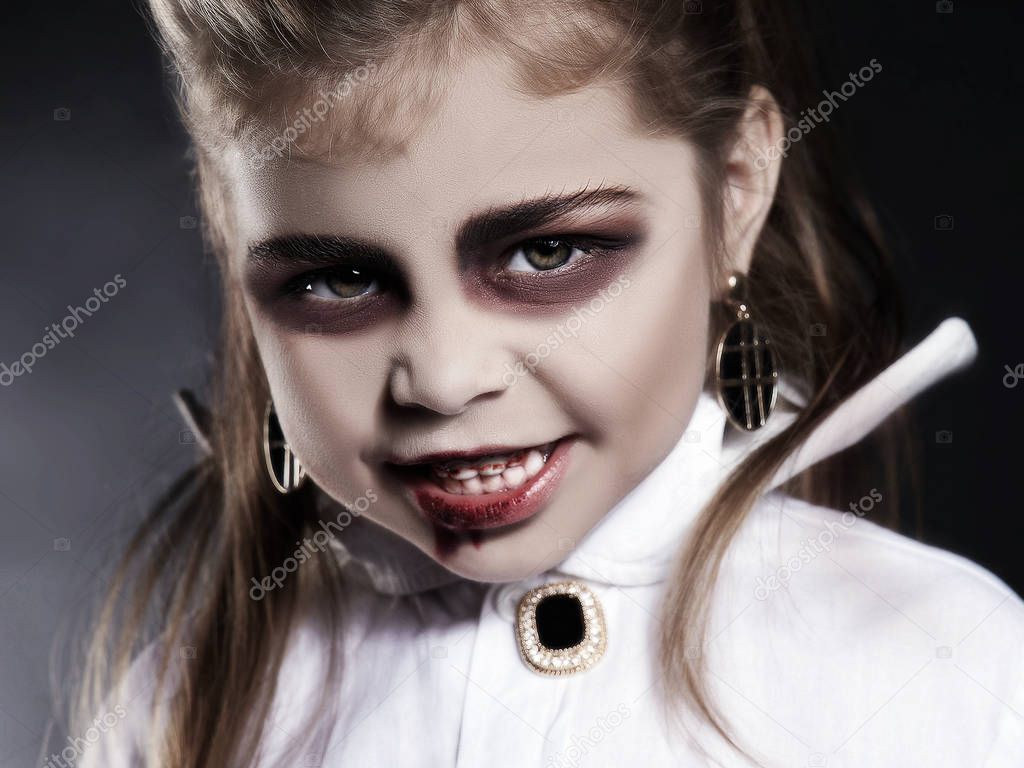 little vimpire child. little angry girl with halloween make-up. dracula kid with blood on her face. halloween holiday children