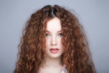 Kıvırcık saçlı ve makyajlı güzel bir kadın. İpek pijamalı güzel seksi kız.