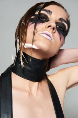 Yüzünde siyah boya olan model bir kadın. Cadılar Bayramı kirli makyajı