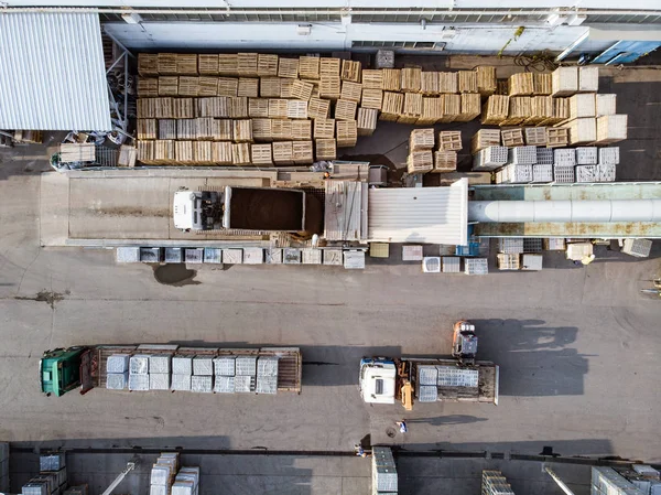 Warehouse of bricks, concrete blocks and trucks by drone