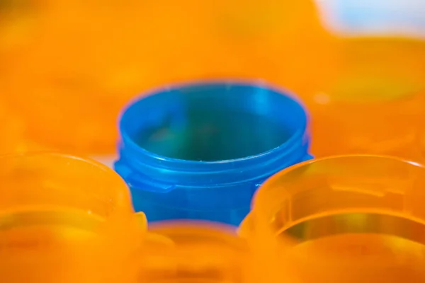 Mavi hapı şişe portakal şişe tarafından çevrili.